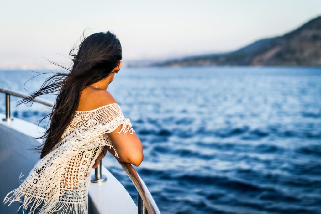 Woman Peacefully Observing the Vastness of the Sea from Aboard a Boat
